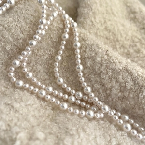 Elegant 925 sterling silver pearl necklace displayed on soft cream textured fabric