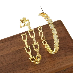 Gold-plated brass heart and chain hoop earrings with cubic zirconia on wood