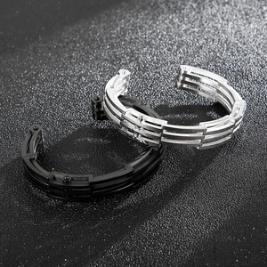Nahaufnahme von silbernen und schwarzen Titanstahl-Bikerarmbändern mit Uhrenarmbandstruktur
