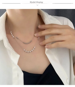 Close-up of double-layer titanium steel necklace with white pearls on a model