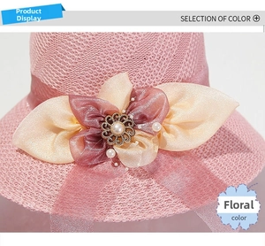 Detailed shot of pink straw hat featuring a large silk flower with pearls and gold accents