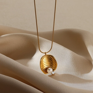 Detail of 18K gold-plated water ripple pendant with pearl and zircon on satin background