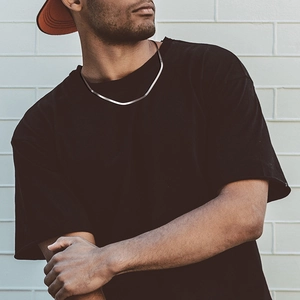 Detailed close-up of a 3mm silver flat snake chain necklace worn by a male model outdoors