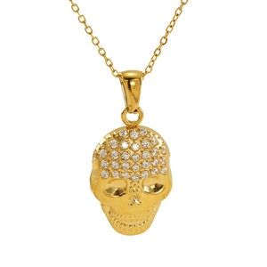 Vue macro d'un pendentif tête de mort doré avec zircons blancs sur une chaîne fine