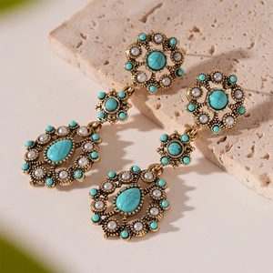 Detailed macro of vintage court-style drop earrings with turquoise and pearls on stone