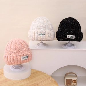 Cozy colorful knitted beanies for kids in pink, beige and black with happy face labels
