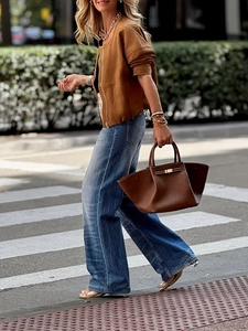 Chaqueta corta vintage marrón para mujer con vaqueros anchos y bolso de mano de cuero