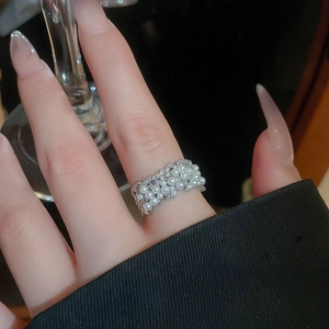 Close-up of a pearl encrusted multi-layer silver open ring worn on a woman finger