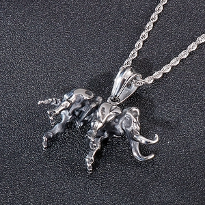 Detailed macro view of vintage elephant skeleton pendant with silver wheat chain