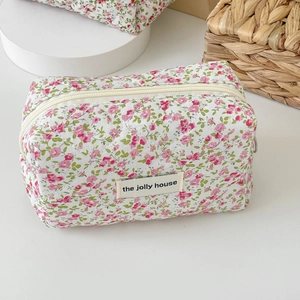 Quilted floral cosmetic bag with pink flower patterns and top zipper for travel storage
