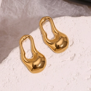 Gros plan sur les boucles d'oreilles goutte dorées 18K avec texture métal liquide