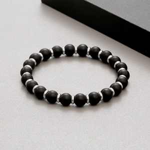 Detailed macro view of matte black agate beads with silver metal spacers on men's bracelet