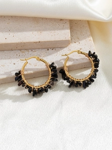 Detail of bohemian gold hoop earrings with hand-wrapped black natural stone beads