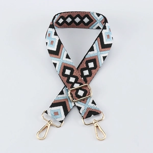 Detail of geometric jacquard bag strap with gold metal lobster clasps and buckle