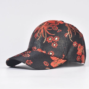 Detail showing red floral embroidery and gold thread on a black silk baseball cap