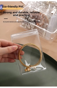Close-up of thick transparent PVC jewelry bag protecting a gold bracelet with zip seal