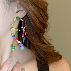 Colorful resin beaded multi-layer hoop earrings worn by a model in a side view