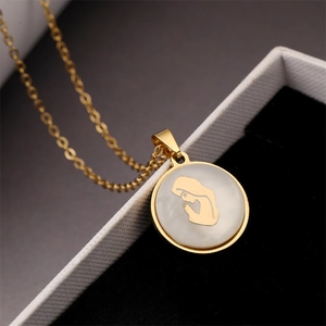 Detailed macro shot of a gold titanium necklace with a mother-of-pearl portrait pendant