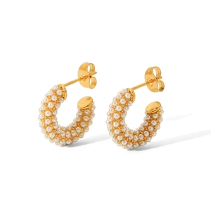 Detail of C-shaped stainless steel earrings with gold plating and white pearl inlay