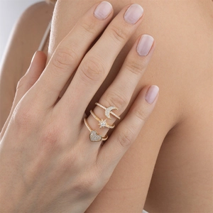 Detail of gold layered rings with moon, star, and heart patterns inlaid with clear zircons