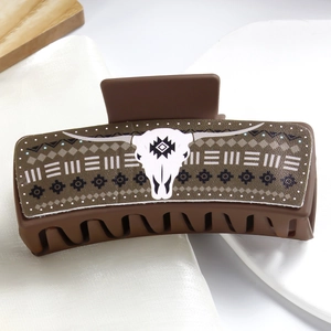 Close-up of brown PU leather claw clip featuring a white cow skull and tribal pattern