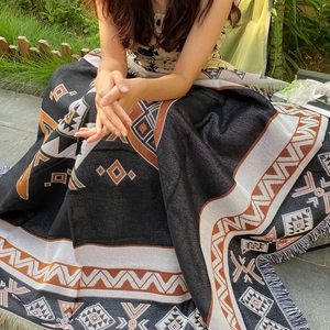 Bohemian style outdoor picnic blanket with geometric pattern and decorative tassels