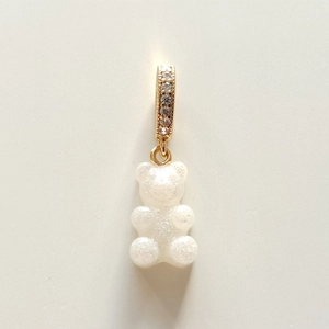 Macro shot of white gummy bear pendant with pearlescent glitter and gold rhinestone clasp