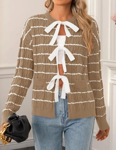 Detail of a brown and white striped knit cardigan with delicate bow tie closures