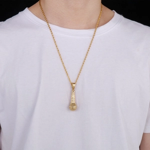 Détail d'un pendentif microphone 3D doré sur une chaîne torsadée porté par un mannequin