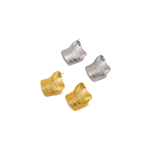 Detail of square titanium steel earrings with gold and silver crocodile texture finish