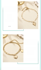 Detailed close-up of 18K gold plated heart pendant and lobster clasp on link bracelet