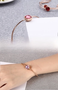 Dettaglio del bracciale geometrico in oro rosa con zircone rosa dal taglio quadrato