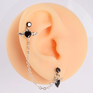 Detail of silver angel wing earrings with black heart stones and delicate link chain