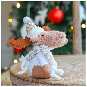 Close-up of a plush Christmas reindeer with knitted hat and scarf in a festive setting