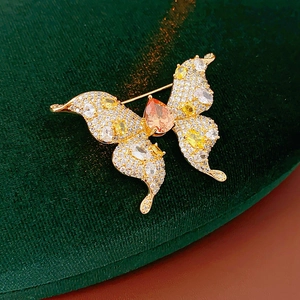 Detailed close-up of a gold-plated butterfly brooch with sparkling colorful zircon stones