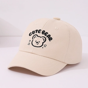 Détail de la broderie d'ours et du texte sur une casquette en coton beige pour bébés