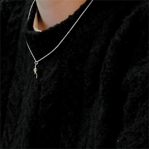 Close-up of minimalist 925 sterling silver knotted pendant necklace worn on black sweater
