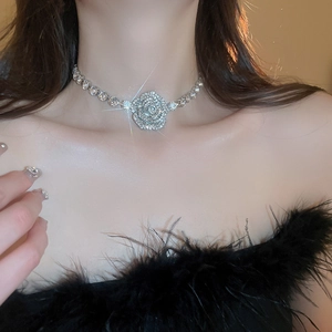 Close-up of sparkling rhinestone flower choker necklace on model's neckline