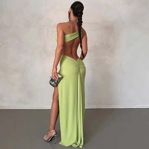 Detail of avocado green two-piece gown with back cutout and ruching on the high-slit skirt