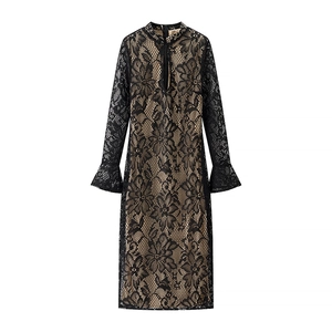 Detail of elegant black lace dress featuring trumpet sleeves and beige lining contrast