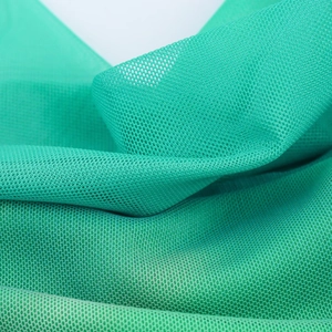 Macro shot of emerald green mesh fabric showing breathable honeycomb texture and softness