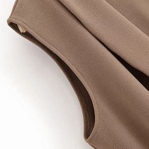 Detail of coffee brown ribbed fabric with precision stitching on a cross-collar top