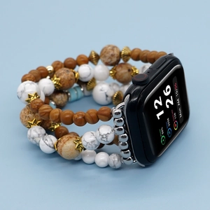Detailed view of beaded Apple Watch strap featuring wood, stone beads and gold star charms