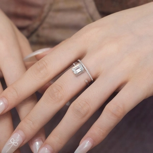 Macro shot of silver ring with radiant emerald cut crystal and pavé set diamonds