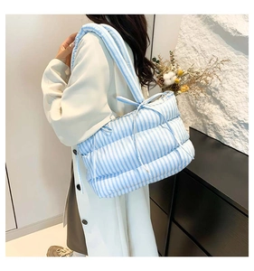 Détail du sac fourre-tout matelassé à rayures bleues et blanches sur mannequin
