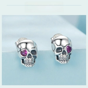 Detail of S925 silver skull earrings featuring purple heart zircon stones and hallmark
