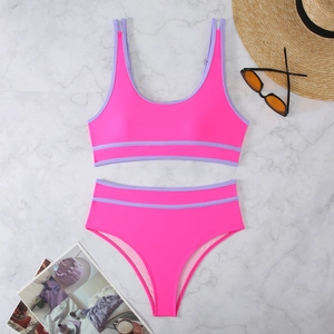 Detailed flat lay of pink and purple high-waisted bikini with summer beach accessories