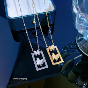 Titanium steel butterfly pendant necklaces in gold and silver finishes on elegant display