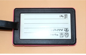 Detail of PVC luggage tag back with pink edge and fields for name, address, and phone