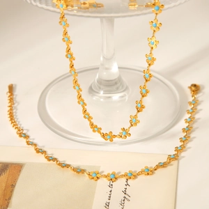 18K gold stainless steel necklace with light blue enamel flower charms on white background